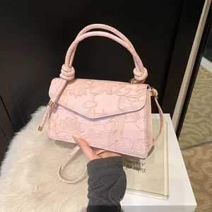 Detail of pink handbag with 3D lotus and carp relief pattern and knot handle
