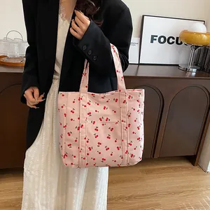 Détail du sac cabas en velours côtelé rose avec imprimé cerise et poche avant pratique