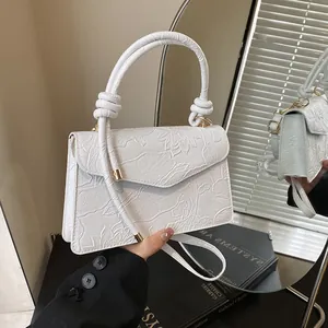 White fashion leather handbag with embossed lotus patterns and twisted handle design