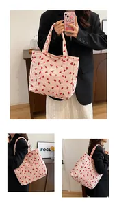 Detail view of pink corduroy tote bag with strawberry print showing carrying styles