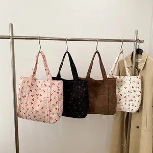 Détail de cabas en velours côtelé à imprimé cerise en rose, noir, marron et beige