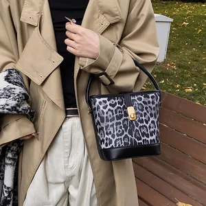 Retro leopard print bucket bag with black leather handle and gold twist-lock closure