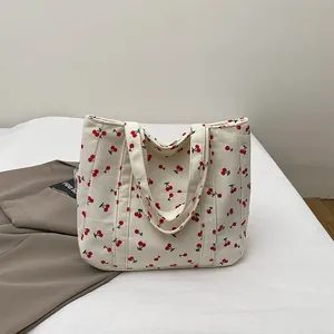 Gros plan du sac cabas en velours côtelé avec motifs cerises et texture rainurée