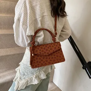Retro brown embossed square shoulder bag with a knotted handle and adjustable strap