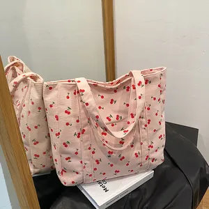Détail du sac cabas en velours côtelé rose avec motifs cerises et grand volume