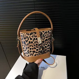 Vintage leopard print bucket bag with brown leather trim and metallic clasp closure