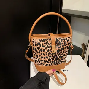 Leopard print bucket bag with tan leather trim and golden twist lock for women