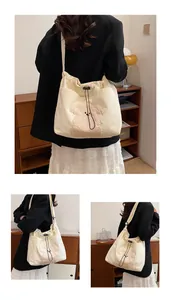 Detail of off-white corduroy tote bag featuring plush bear decor and drawstring closure