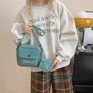 Detail of mint green crossbody bag with round coin purse and white Dachshund lettering