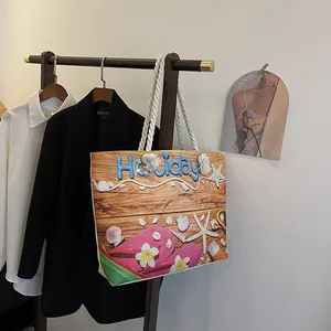 Détail du sac de plage en toile avec imprimé Holiday, motifs coquillages et anses cordes