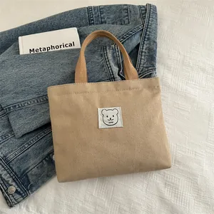 Gros plan d'un sac cabas en toile kaki avec broderie ours et poignées en corde épaisses