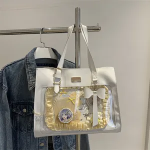 Detail of white ita bag with yellow ruffles, large bow, and transparent display window