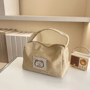 Detail of corduroy makeup bag with cute bear embroidery and smooth zipper closure