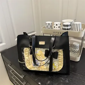 Detail of black ita bag with clear PVC window showing badges and yellow liners