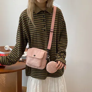 Pink canvas crossbody bag featuring letter print and a detachable round coin purse