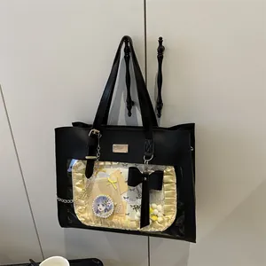 Detail of black ita tote bag with large transparent window and yellow ruffle inner decor