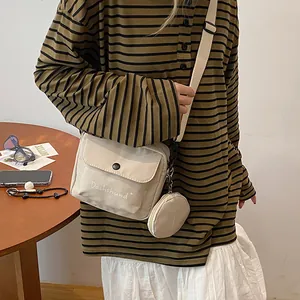 Detail of off-white canvas crossbody bag with mini coin purse and Dachshund letter embroidery