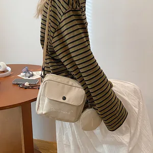 Detail of cream crossbody bag with Dachshund text and matching round coin purse pouch