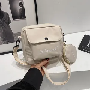 Detail of canvas crossbody bag with mini round coin purse and white Dachshund lettering