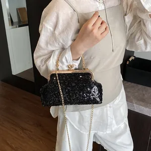 Détail de l'élégant sac de soirée à paillettes noires avec monture et chaîne dorées