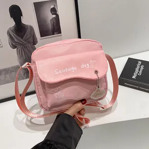 Pink nylon crossbody bag with sausage dog print and a cute matching charm accessory