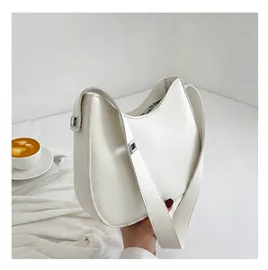 Close-up van een witte leren hobo-tas met zilveren details en een brede schouderriem