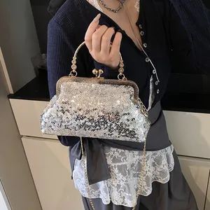 Détail de la pochette de soirée à paillettes argentées avec anse fleurie dorée
