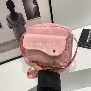 Pink canvas crossbody bag featuring cute sausage dog print and wave-edge flap detail