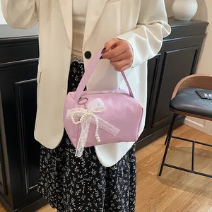 Detail of lavender handbag with lace and pearl bow held by model in retro style