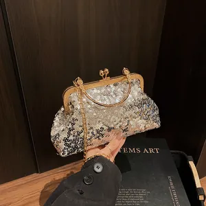 Détail de la pochette de soirée à paillettes argentées avec poignée dorée et chaîne