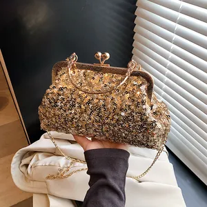 Détail de la pochette de soirée à paillettes dorées avec cadre en métal sculpté et poignée