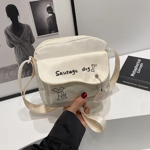 Minimalist beige crossbody bag with cute sausage dog print and adjustable strap