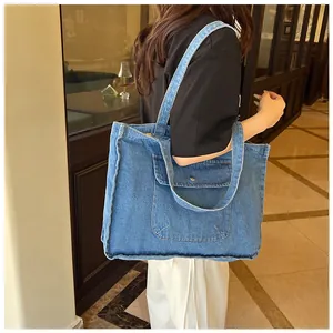 Detailansicht der blauen Denim-Tragetasche mit großer Frontklappe und Metallknopf
