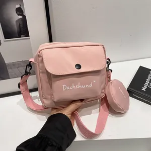 Detail view of pink nylon crossbody bag with small round pouch and Dachshund print