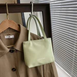 Dettaglio della mini borsa verde menta con trama in pelle increspata e stampa logo bianca