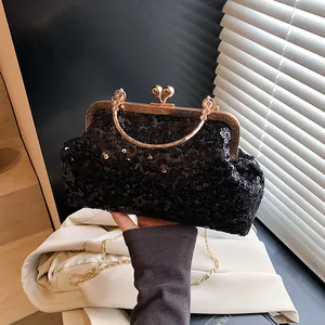 Détail de pochette de soirée noire à paillettes avec cadre doré et poignée fleur