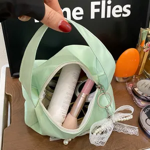Top view of mint green cosmetic bag showing spacious interior with beauty accessories