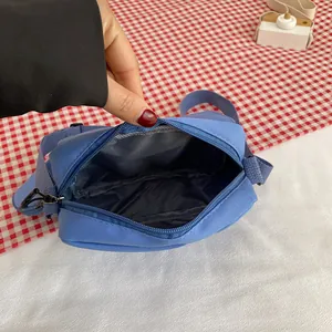 Sky blue nylon crossbody bag with zipper closure and spacious interior compartment