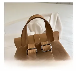 Detail of brown suede backpack showing the comfortable handle and metal adjusting buckles