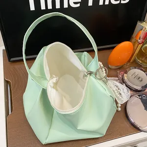 Detail of mint green small handbag interior with cosmetics on wooden desk