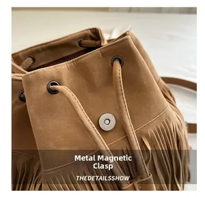Close-up of vintage brown suede backpack featuring a magnetic buckle and tassel details