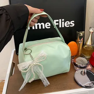 Detail view of mint green PU leather bag with lace bow and imitation pearl charm