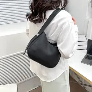 Gedetailleerd achteraanzicht van een zwarte matte hobo zadeltas gedragen door een model