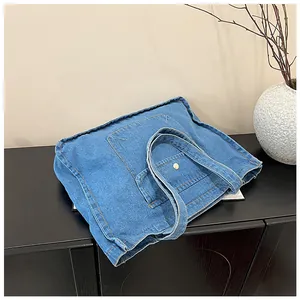 Detailansicht der blauen Denim-Tragetasche mit Metallknopf-Tasche und sauberen Nähten
