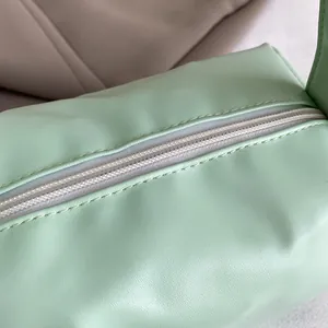 Detail of the high-quality zipper closure on a mint green lychee pattern PU pouch