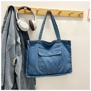 Detail der blauen gewaschenen Denim-Tragetasche mit Metall-Schnallentasche am Bügel