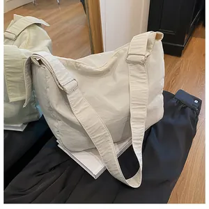 Detail of adjustable wide shoulder strap with silver buckle on minimalist cream tote bag