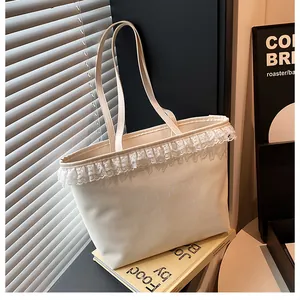 Detailed close-up of cream lace-trimmed tote bag with Evea Glow typography and leather straps