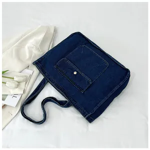 Detail einer dunkelblauen Denim-Tragetasche mit Fronttasche und Metallschließe