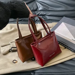 Dettaglio di mini borse a mano retrò in pelle PU lucida marrone e bordeaux scuro